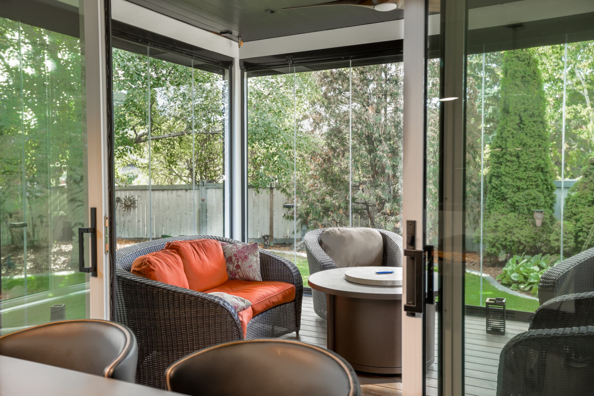 Doorway view into the enclosure with lounge chairs and fire table