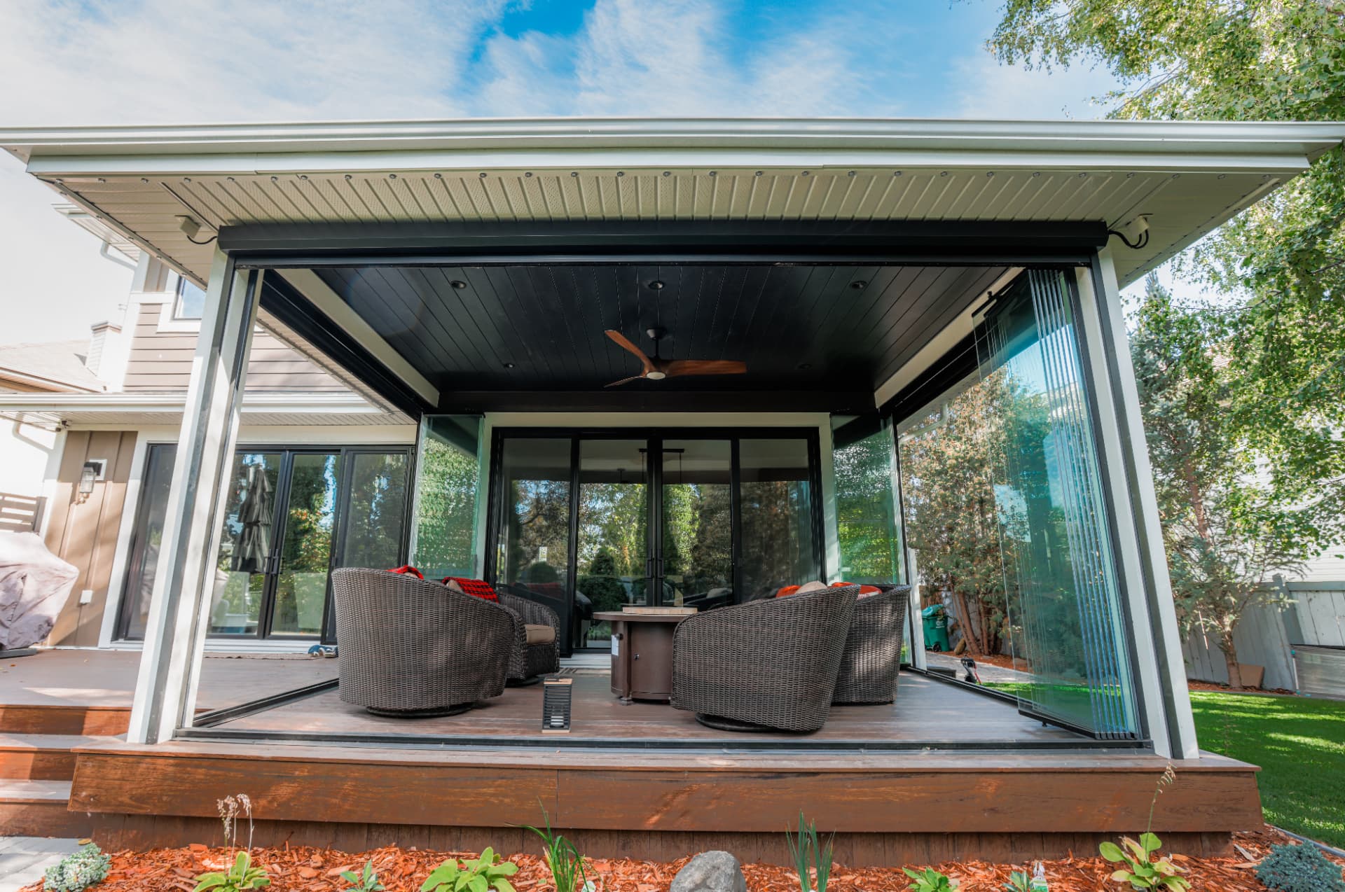 Patio enclosure with the glass walls stacked fully open onto the deck