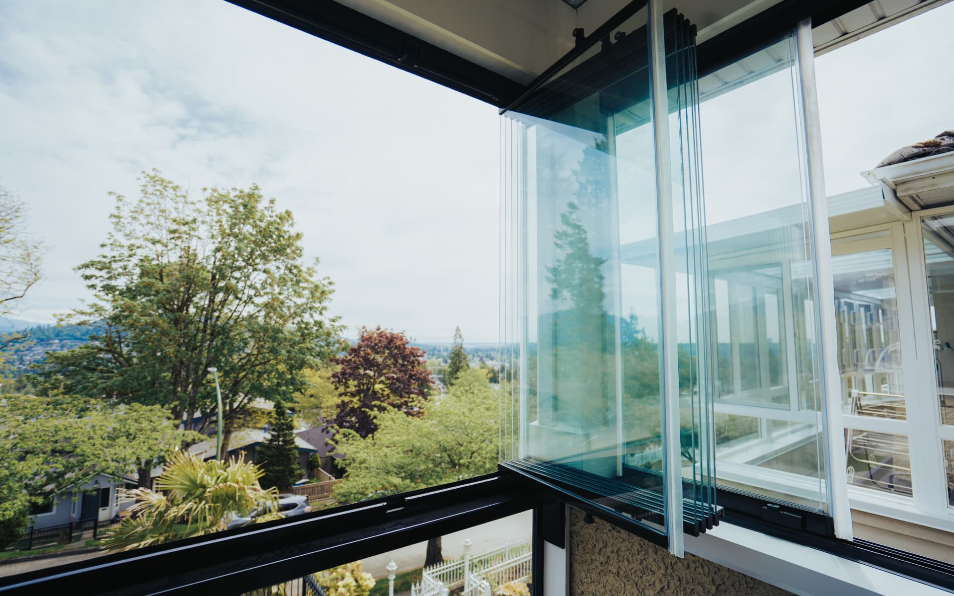 Frameless retractable glass wall onto a garden