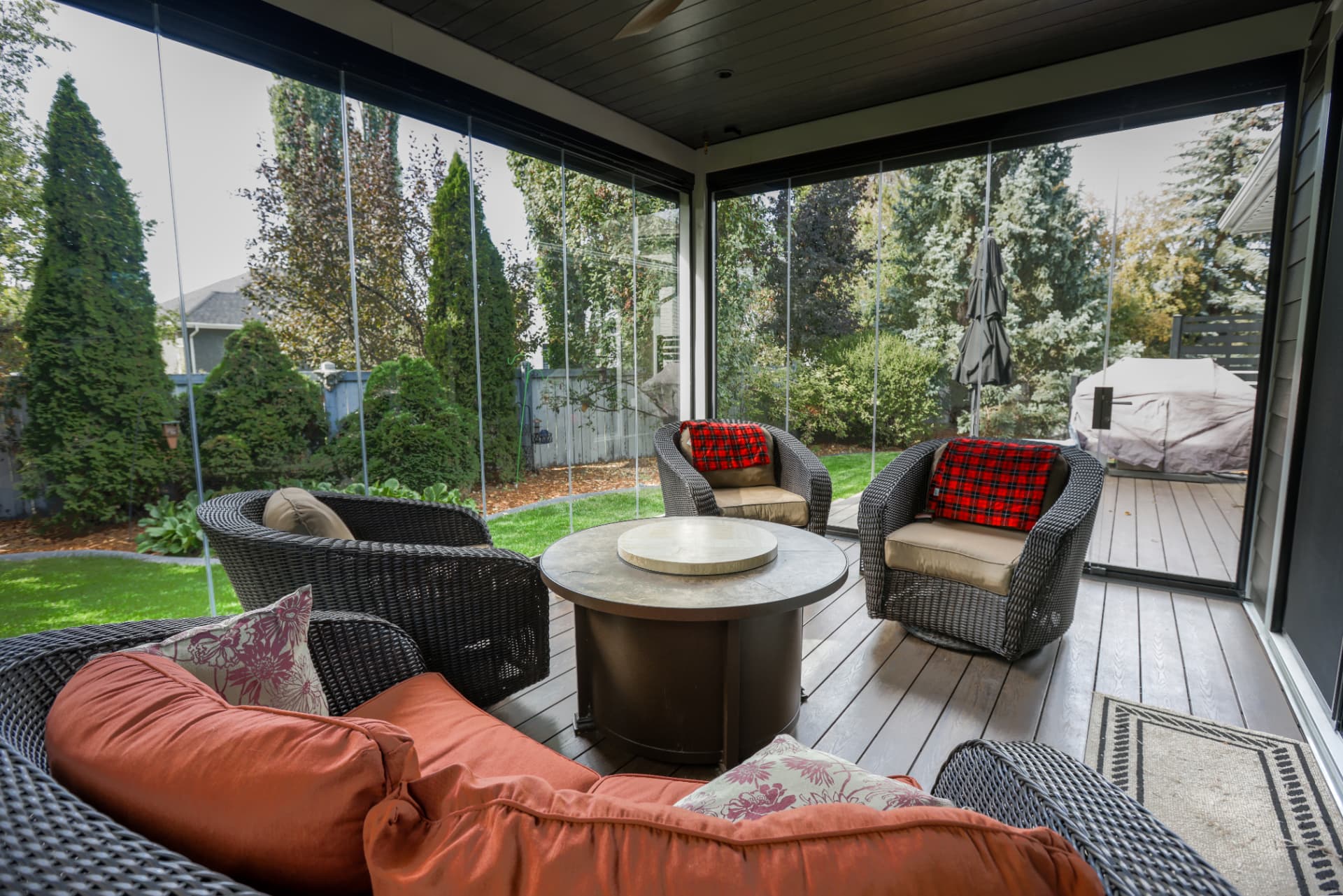 Interior of the enclosure with fire table, wicker seating and garden views