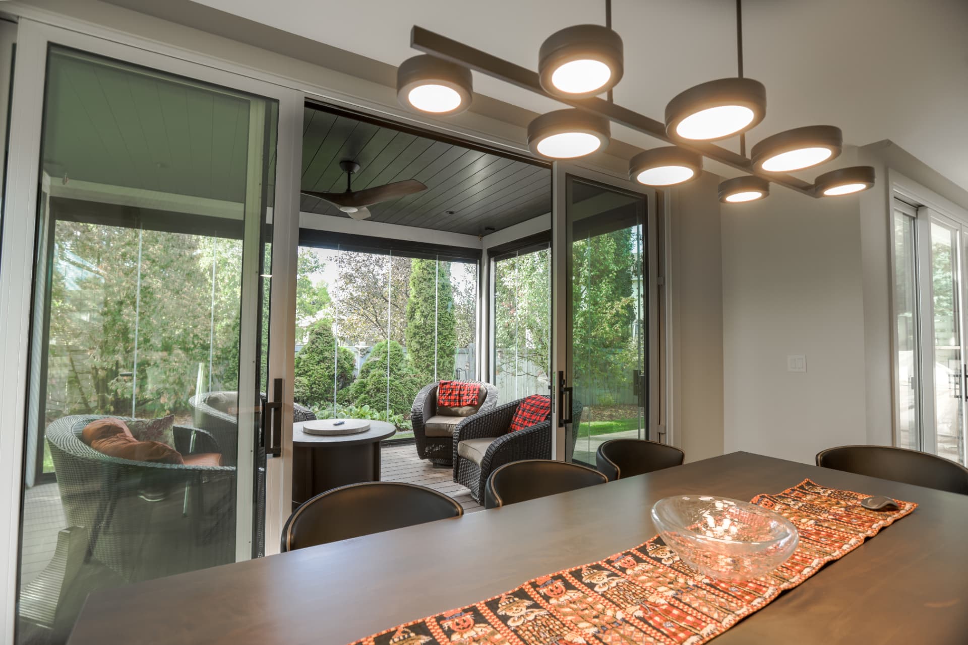 Looking out from the dining room through open doors into the glass enclosure