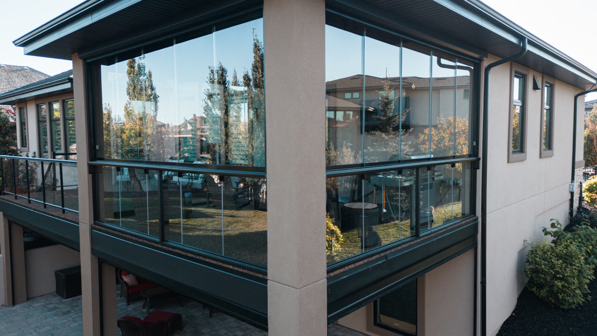 Elevated exterior view of the fully glazed balcony wrapping the corner of the house